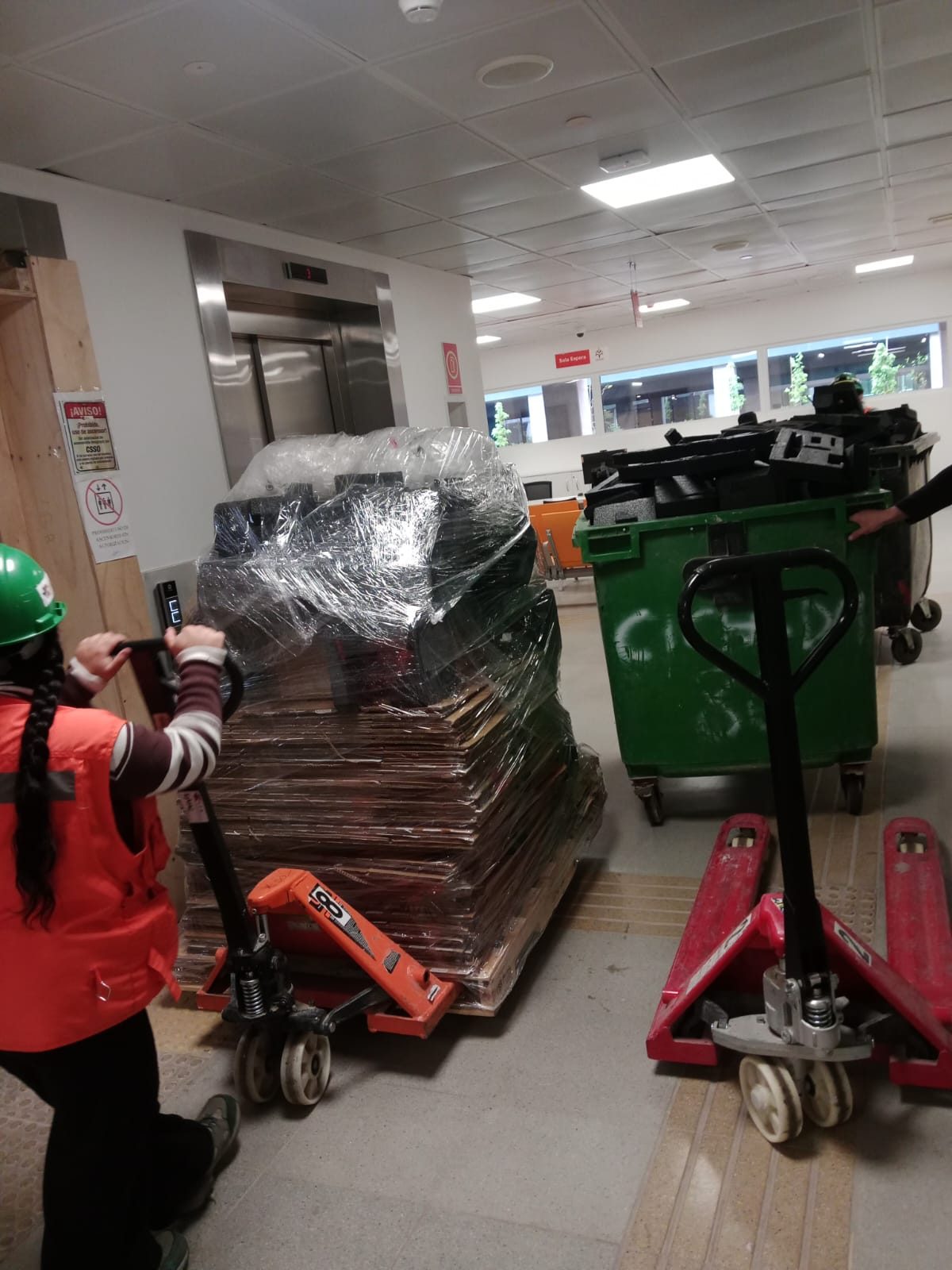 Traslado de carga en transpaleta hacia el ascensor